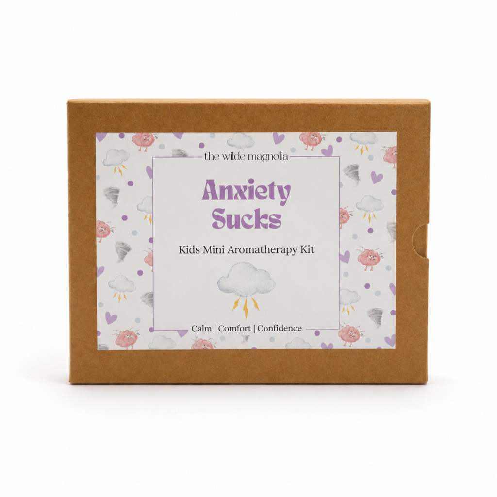 A square kraft paper box for 'Anxiety Sucks Kids Mini Aromatherapy Kit' by 'the wilde magnolia', featuring a white label with purple text and a cloud pattern on a white background.
