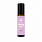 A 10ml amber glass roll-on bottle with a black cap and a lavender purple label that reads 'Anxiety sucks' by the brand 'the wilde magnolia'.