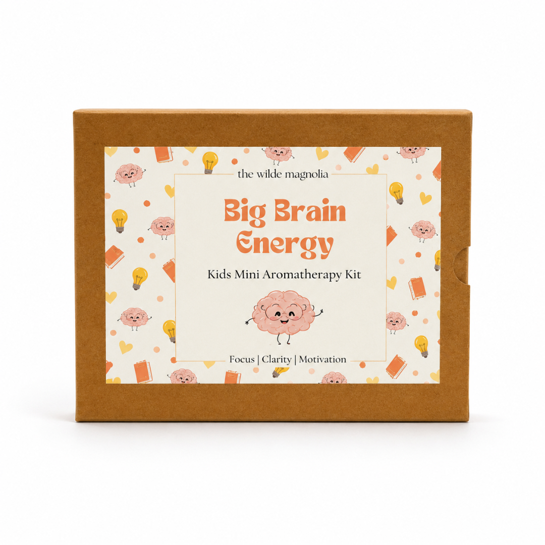 A rectangle kraft brown cardboard box for 'the wilde magnolia Big Brain Energy Kids Mini Aromatherapy Kit' with a colorful cartoon label on the front.