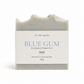 A rectangular bar of soap by 'The Wilde Magnolia' wrapped in a white paper label that reads 'BLUE GUM' with 'Eucalyptus | Peppermint' and 'Fresh' underneath, on a clean white background.
