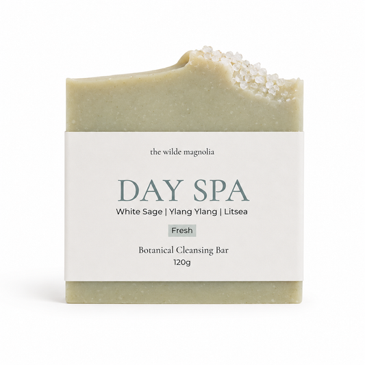 A single rectangular botanical cleansing bar wrapped in a white paper label reading 'the wilde magnolia DAY SPA White Sage | Ylang Ylang | Litsea Fresh Botanical Cleansing Bar 120g', photographed on a clean white background.