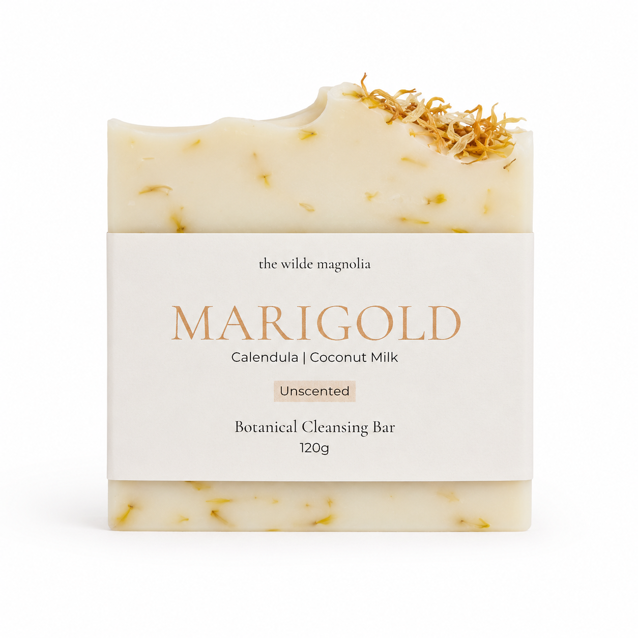 A rectangular bar of MARIGOLD unscented botanical cleansing soap by The Wilde Magnolia, featuring a cream-colored body with visible yellow calendula petals and a white paper label wrapped around the center.