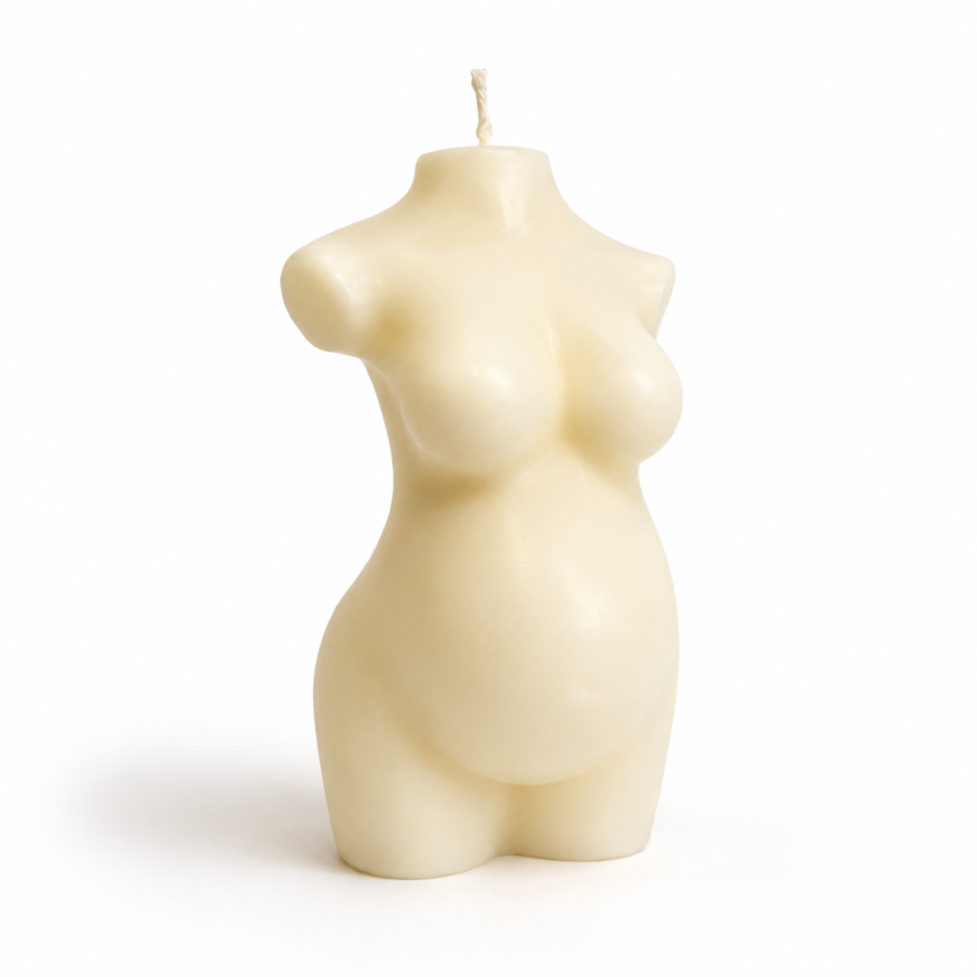 An ivory coloured candle shaped like a pregnant female torso, standing on a white background with a soft shadow.