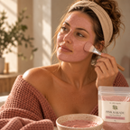 woman applying a pink clay face mask with a brush