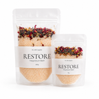 2 clear pouches of Restore Magnesium Salt Soak 200g and 75g on a white backgound