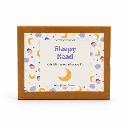 The Wilde Magnolia 'Sleepy Head' Kids Mini Aromatherapy Kit in its brown kraft paper box packaging, featuring a whimsical label with purple text and yellow crescent moons on a white background.