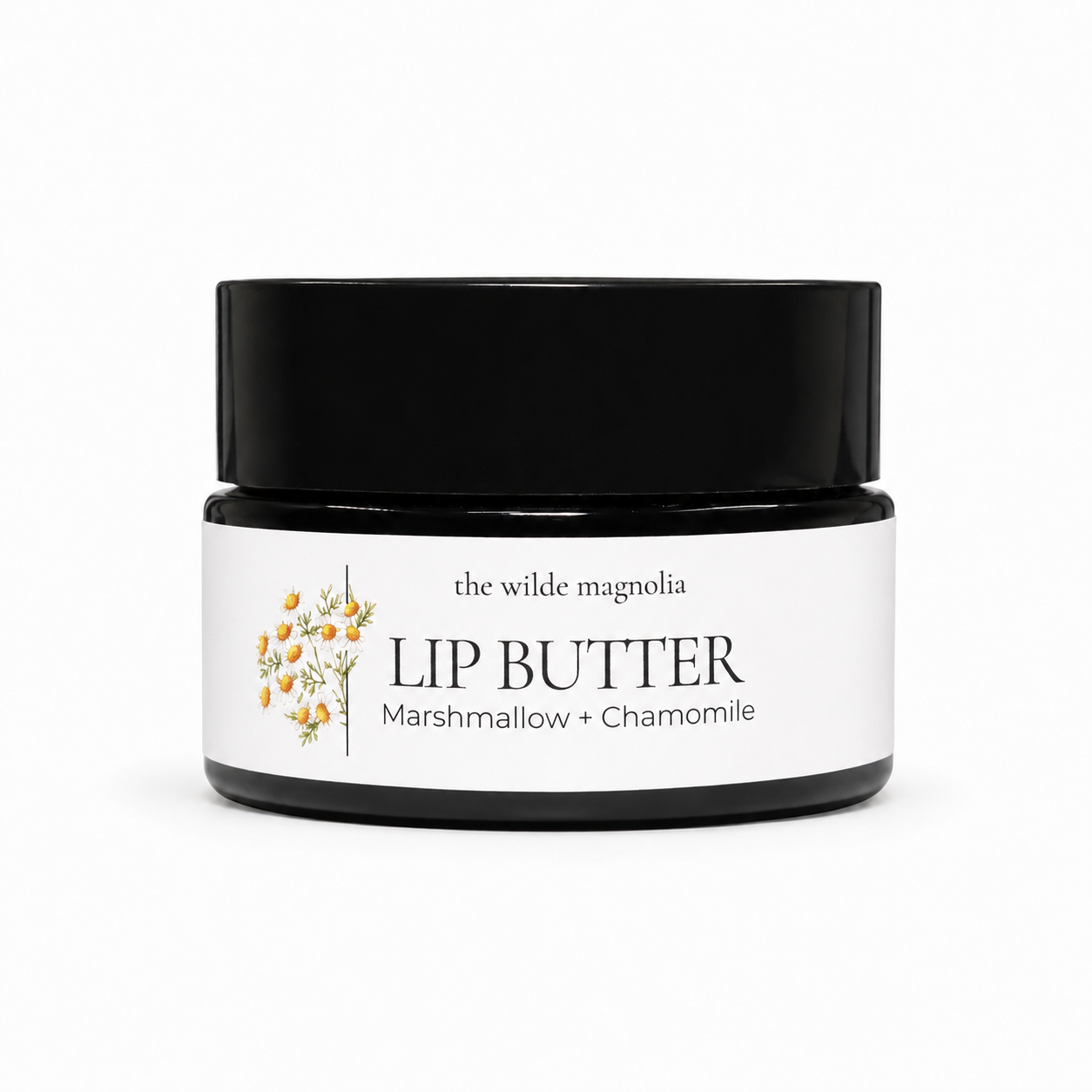 An amber jar of lip butter with a white label reading 'the wilde magnolia LIP BUTTER Marshmallow + Chamomile' and a small floral illustration, photographed on a clean white background.